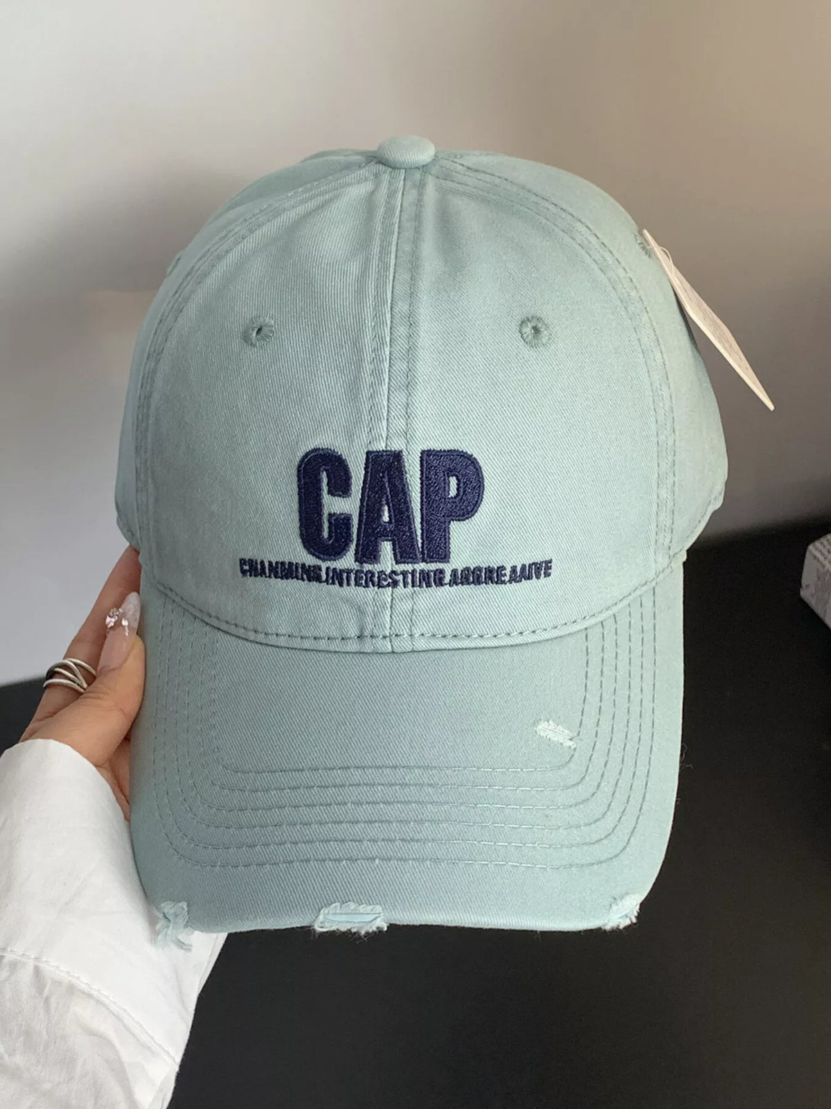 Close detail of the distressed brim edge and embroidery