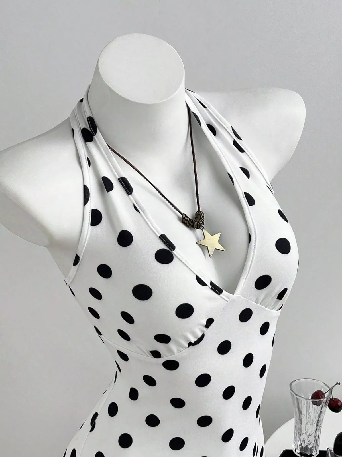 Polka dot romper side view showing the halter neckline