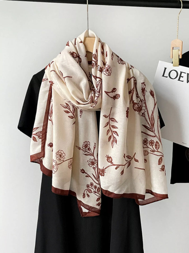 Floral print lightweight scarf draped around the neck