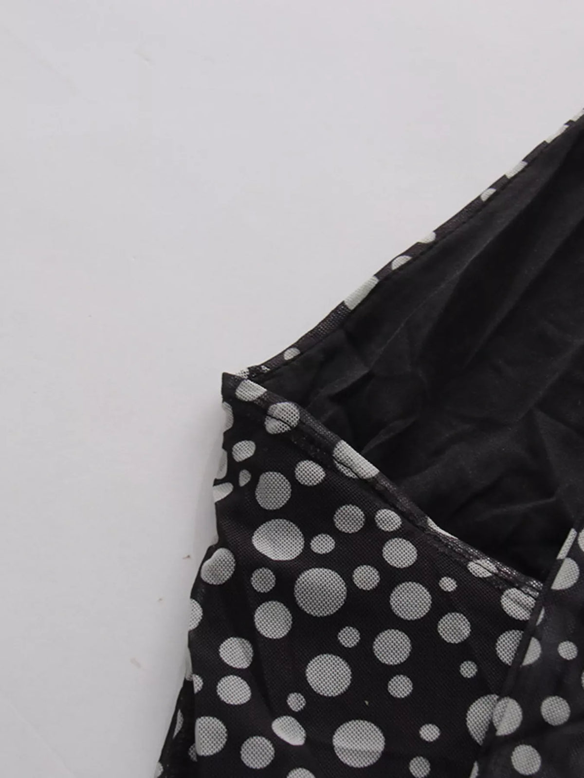 Black halter neck polka dot maxi dress, seated styling view