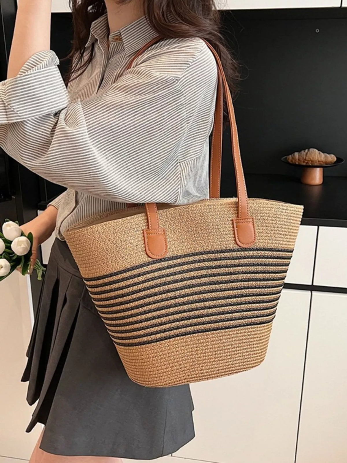 Straw shoulder bag held by model