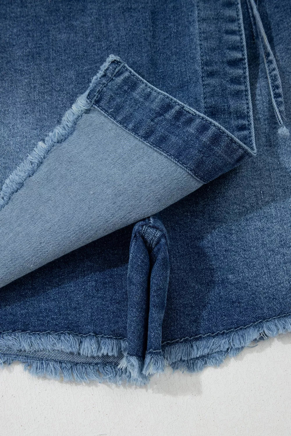 Medium wash wrapped tie waist denim skort detail view