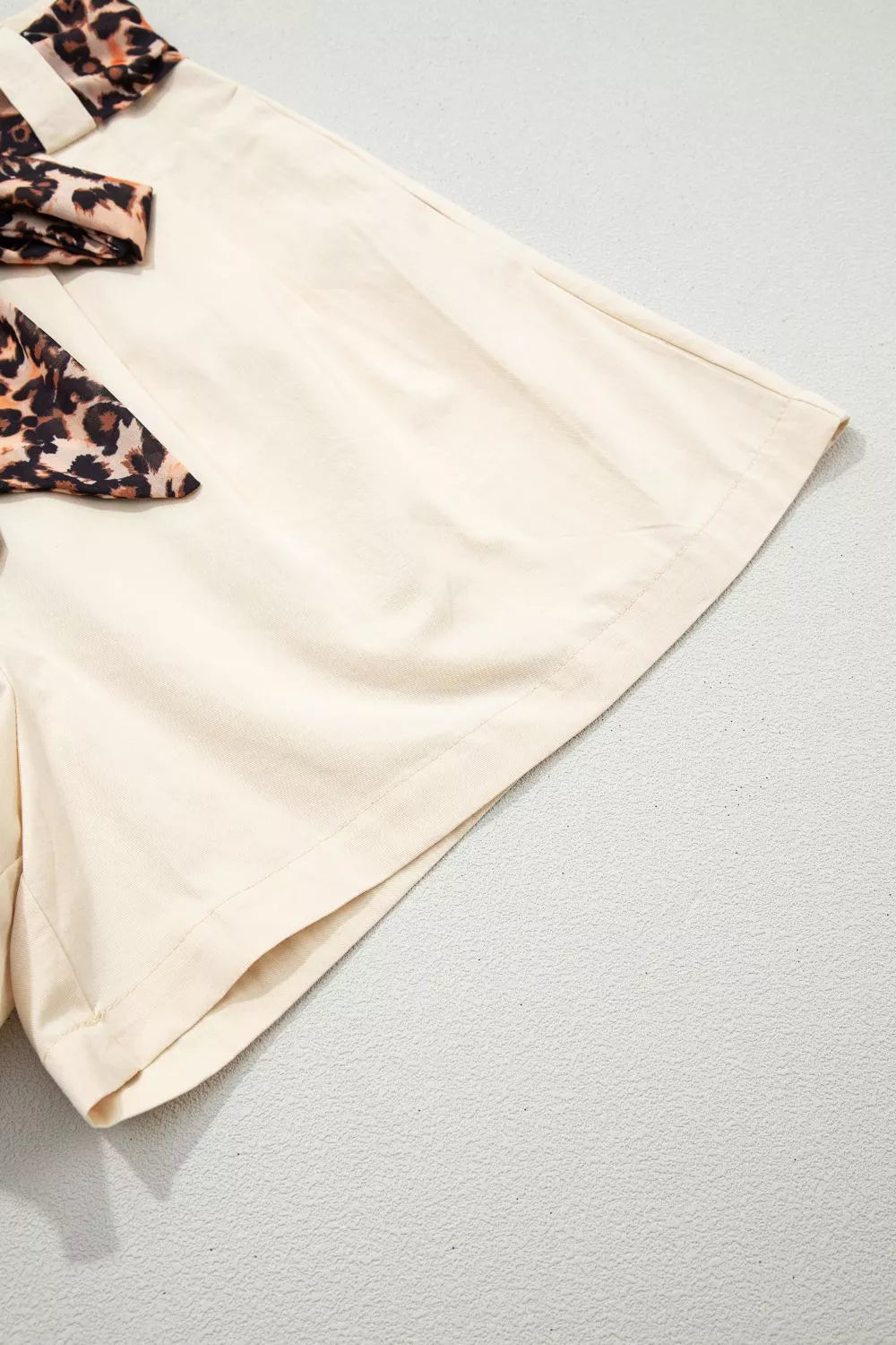 Beige high waisted pleated shorts flat lay view