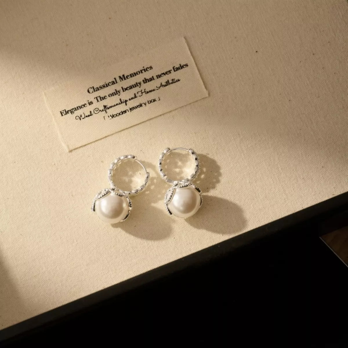 Pearl hoop earrings with zircon accents in silver tone, styled outfit