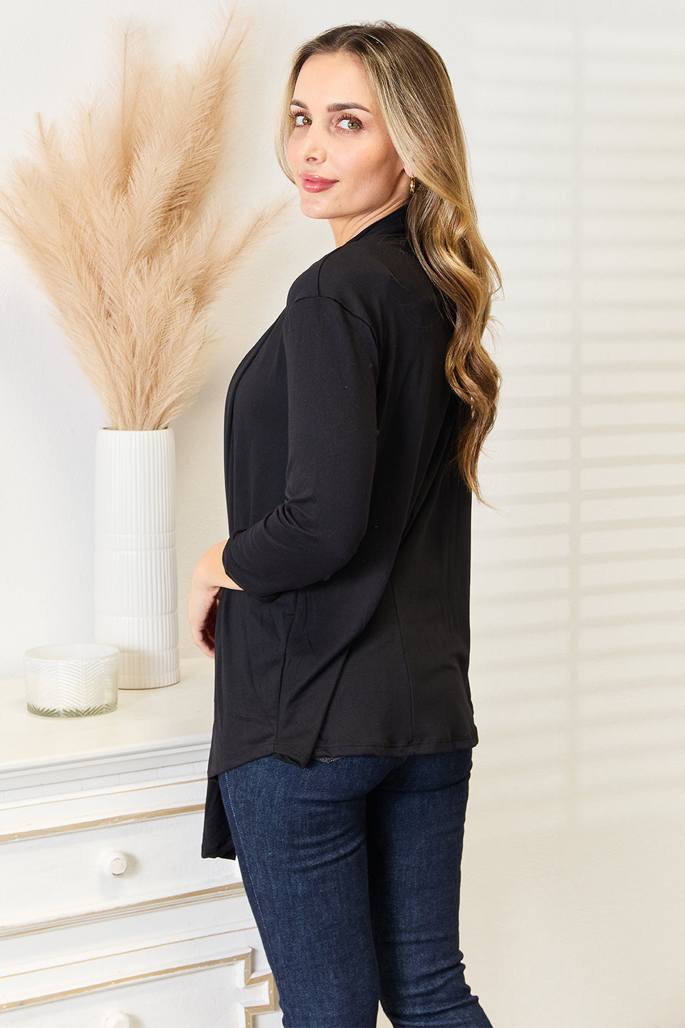 Draped front detail of black open front cardigan