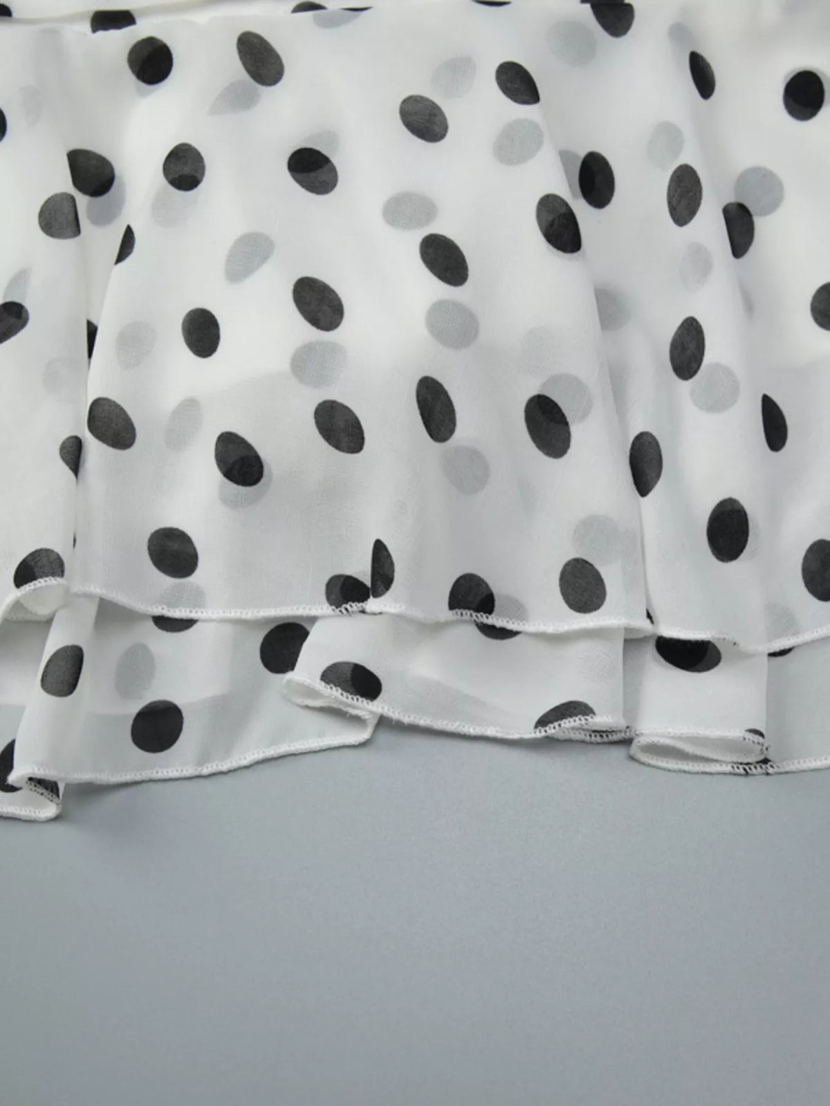 Three quarter view of the white polka dot dress