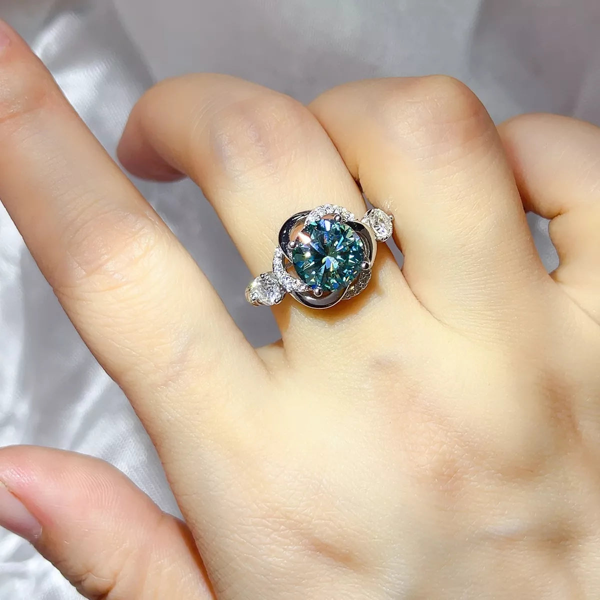 3 carat green moissanite swirl halo ring in sterling silver worn on the hand