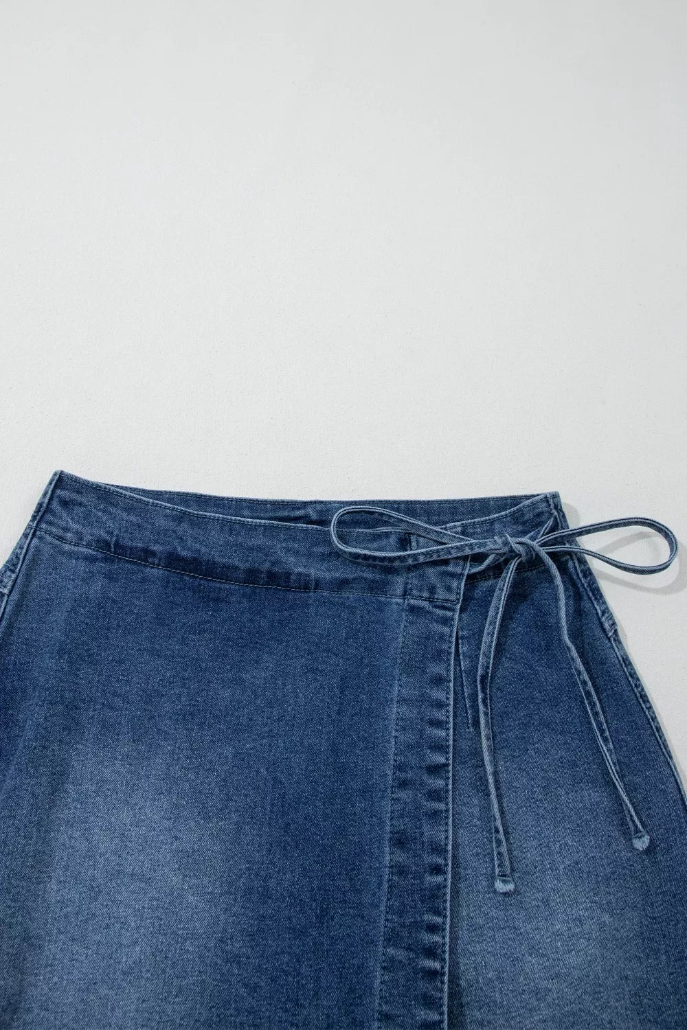 Medium wash wrapped tie waist denim skort side view