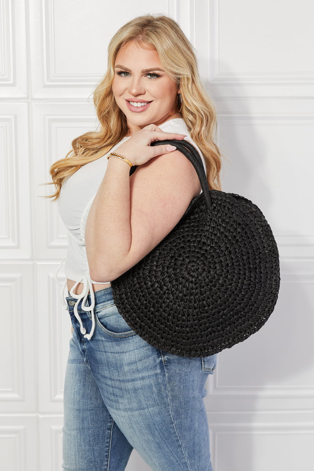 Black woven straw handbag carried on shoulder