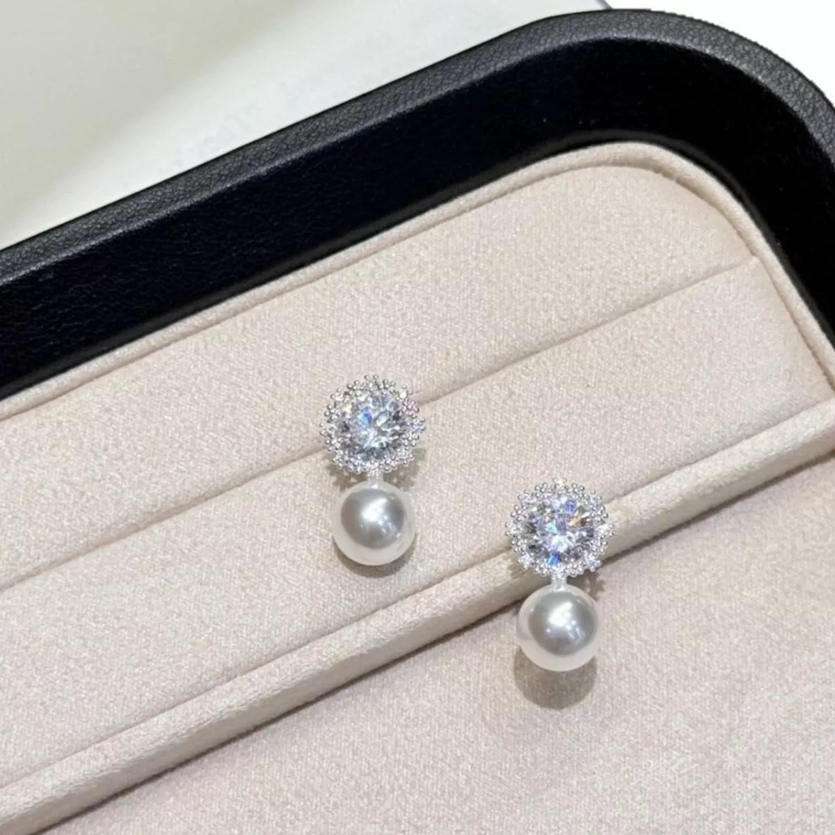 Pearl and zircon earrings pair laid flat