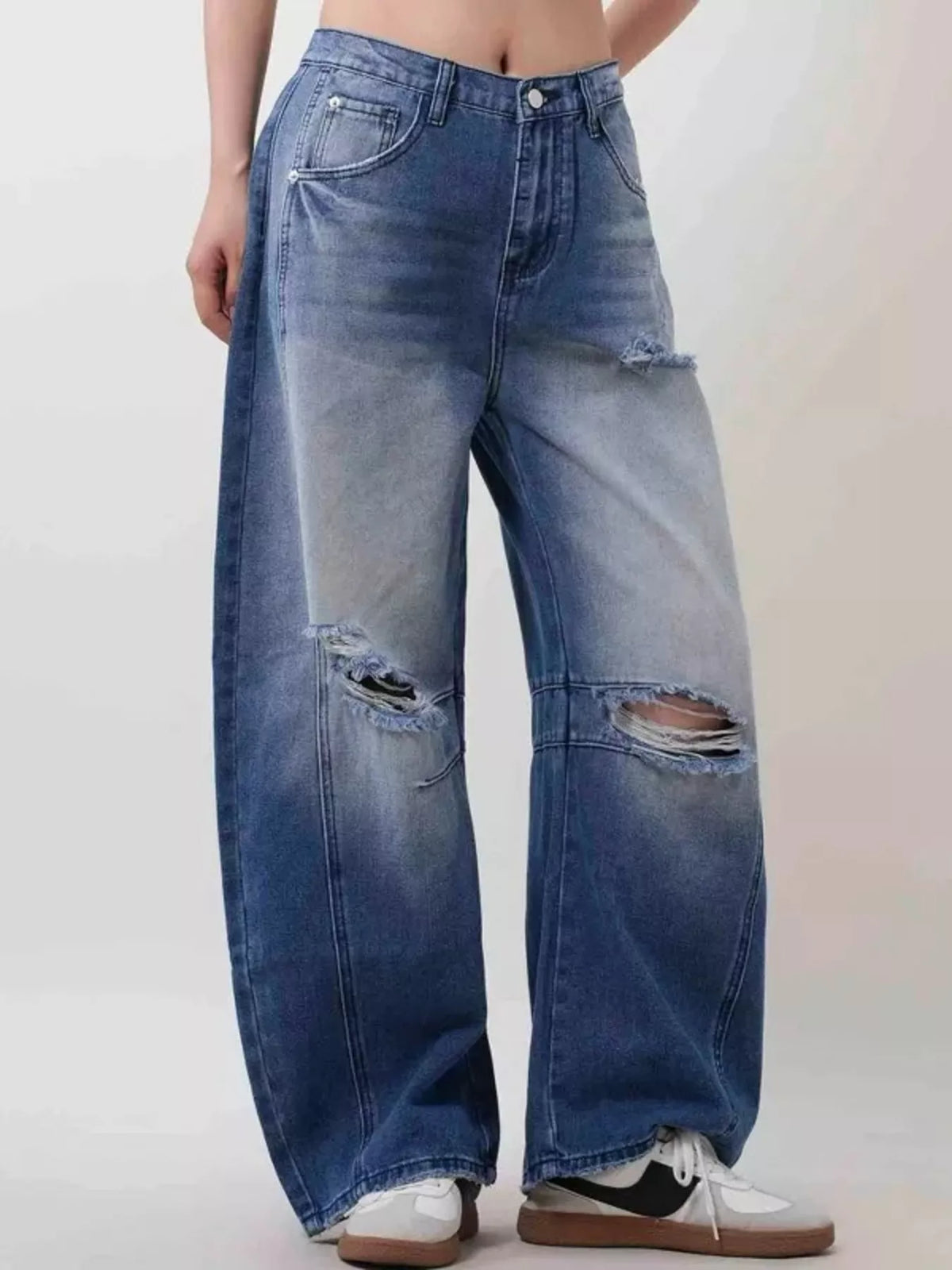 Model wearing distressed two tone jeans