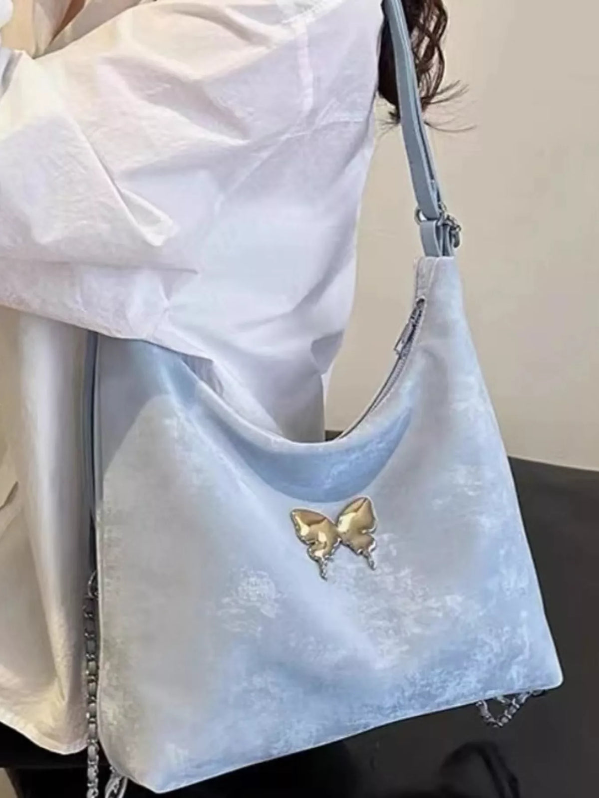 Butterfly detail on blue shoulder bag