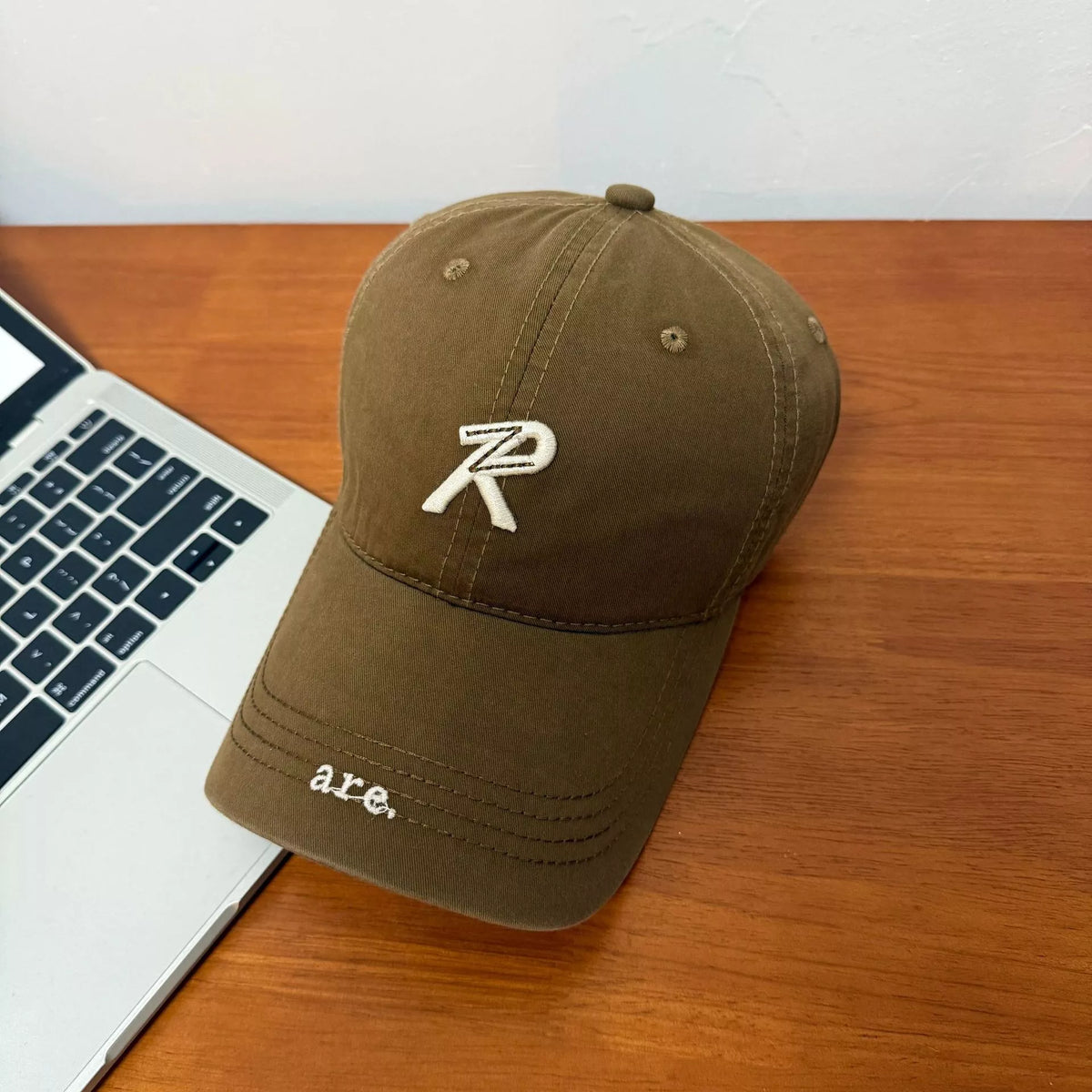 Letter embroidered baseball cap in dark brown, front view