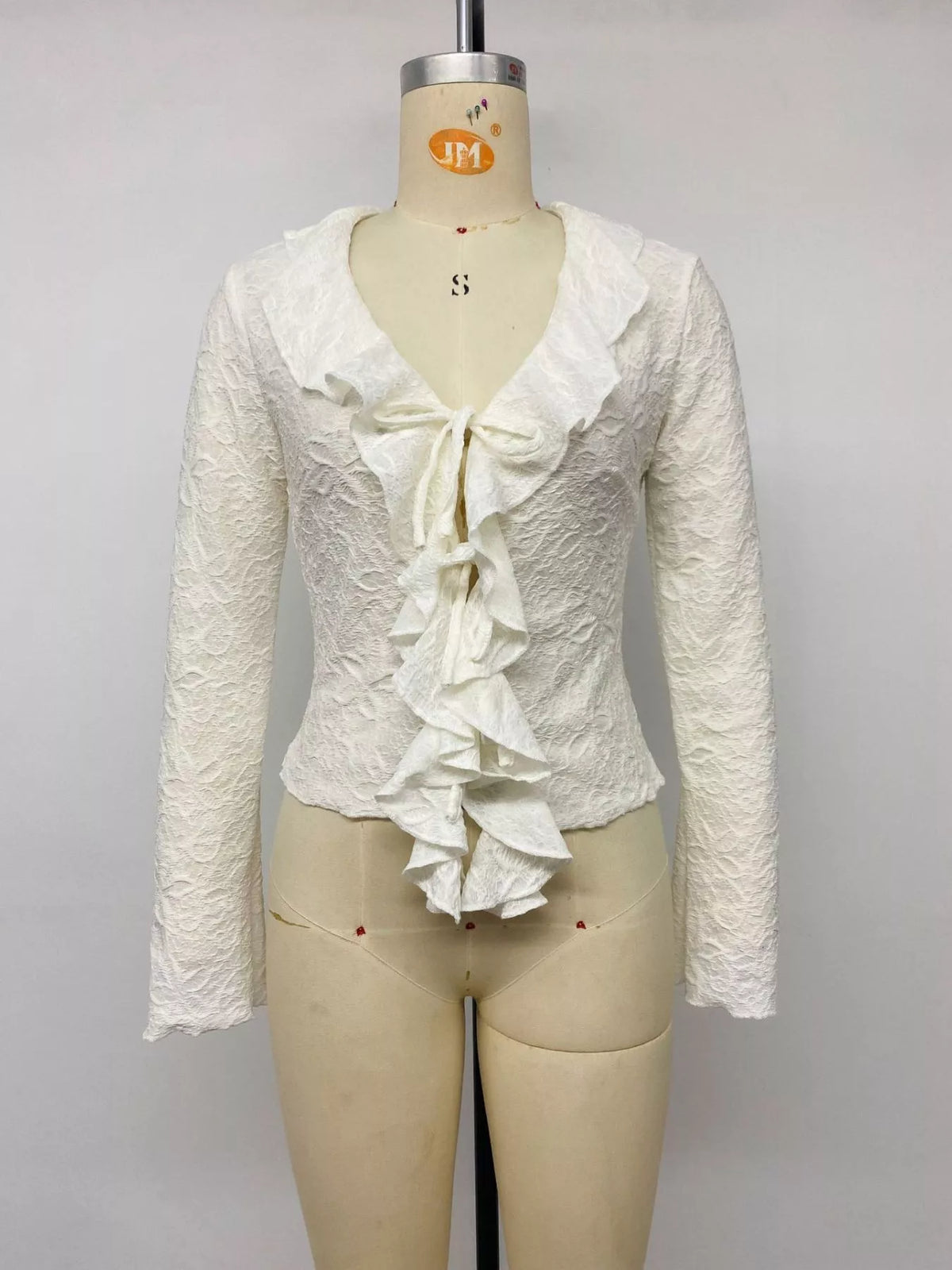 Three quarter view of apricot ruffled long sleeve tee