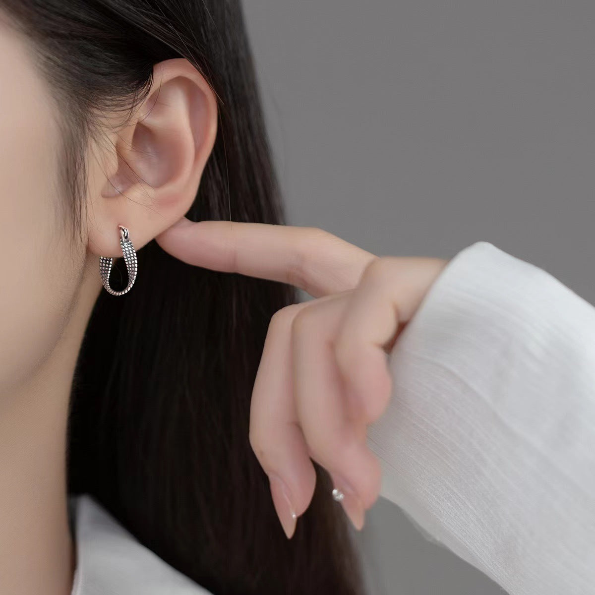 Sterling silver hoop earrings worn on the ear
