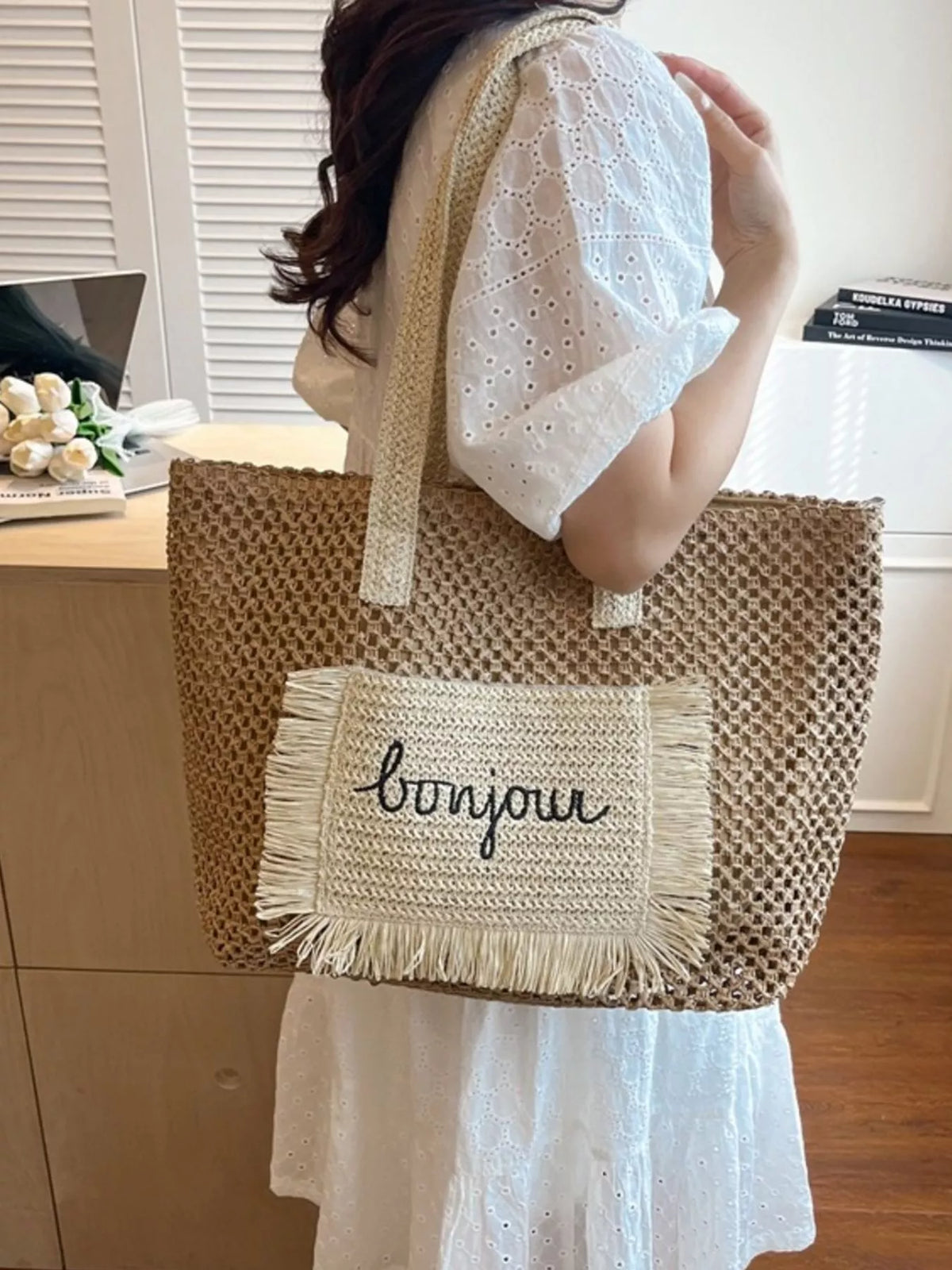 Straw fringe bag held on shoulder