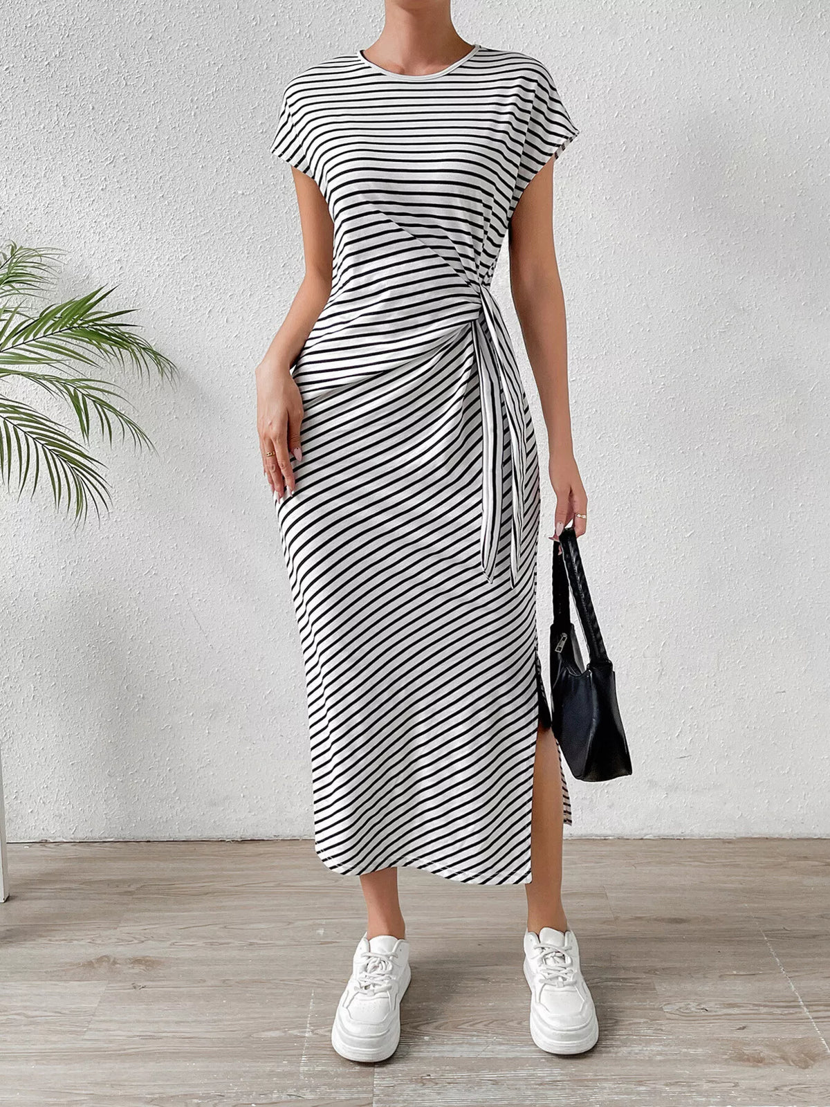 Black striped dress styled on model, side angle