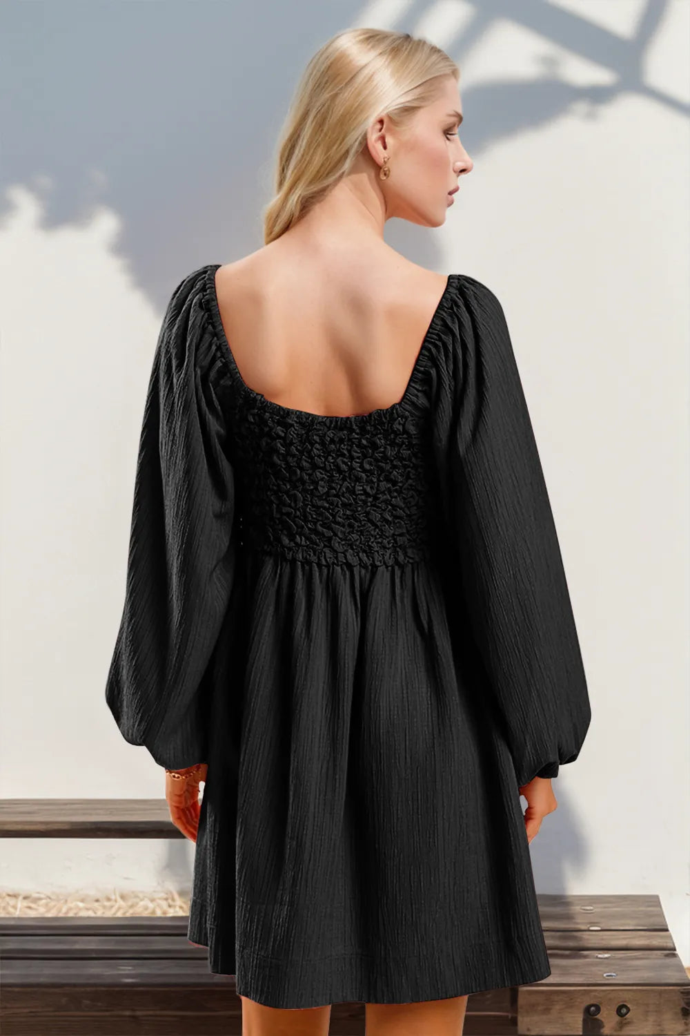 Balloon sleeve and smocked detail on black mini dress