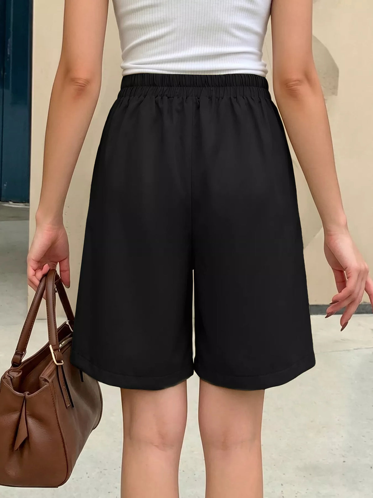 Black high waisted pleated shorts back view