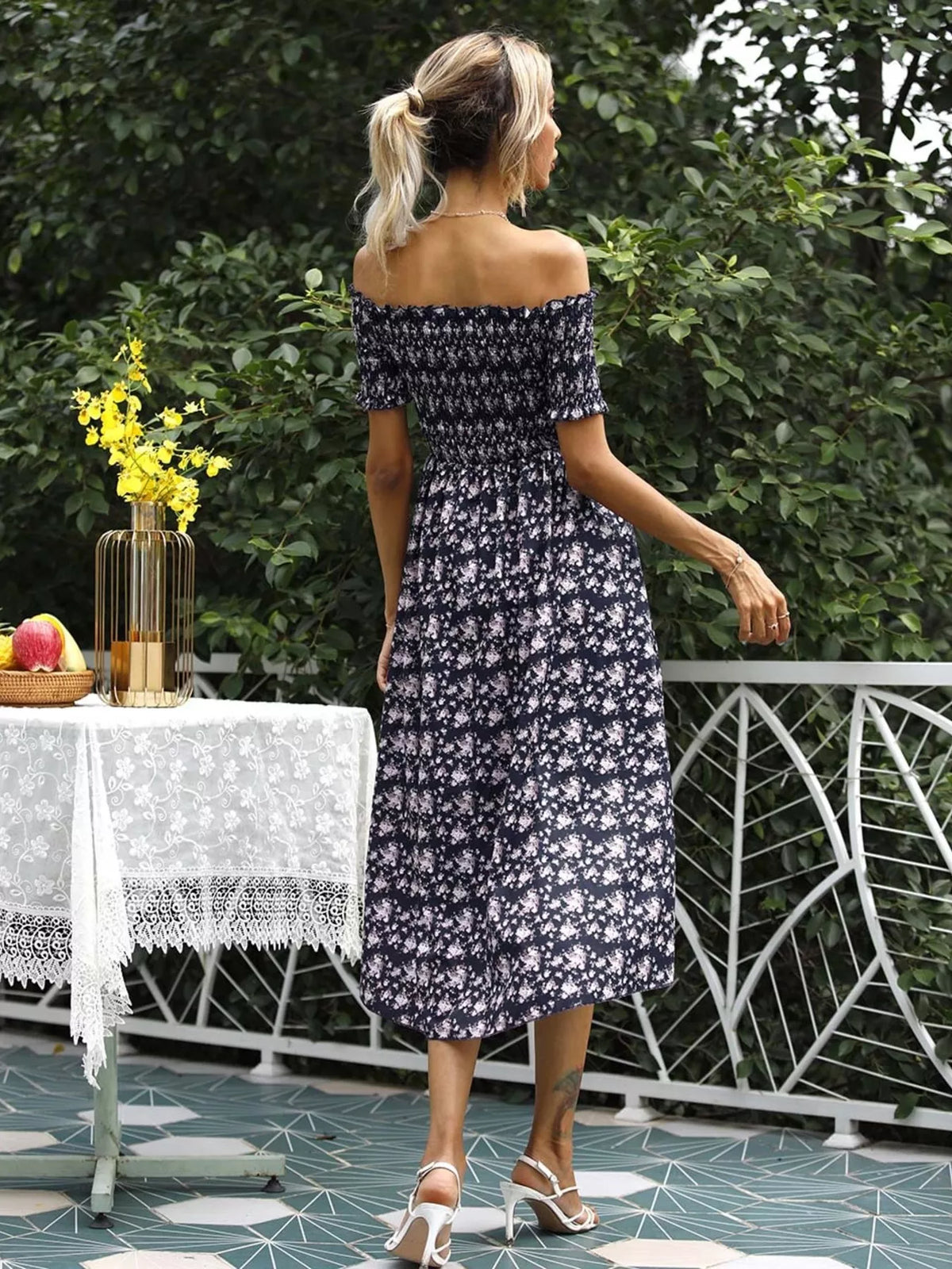Off shoulder floral dress worn walking to show the slit