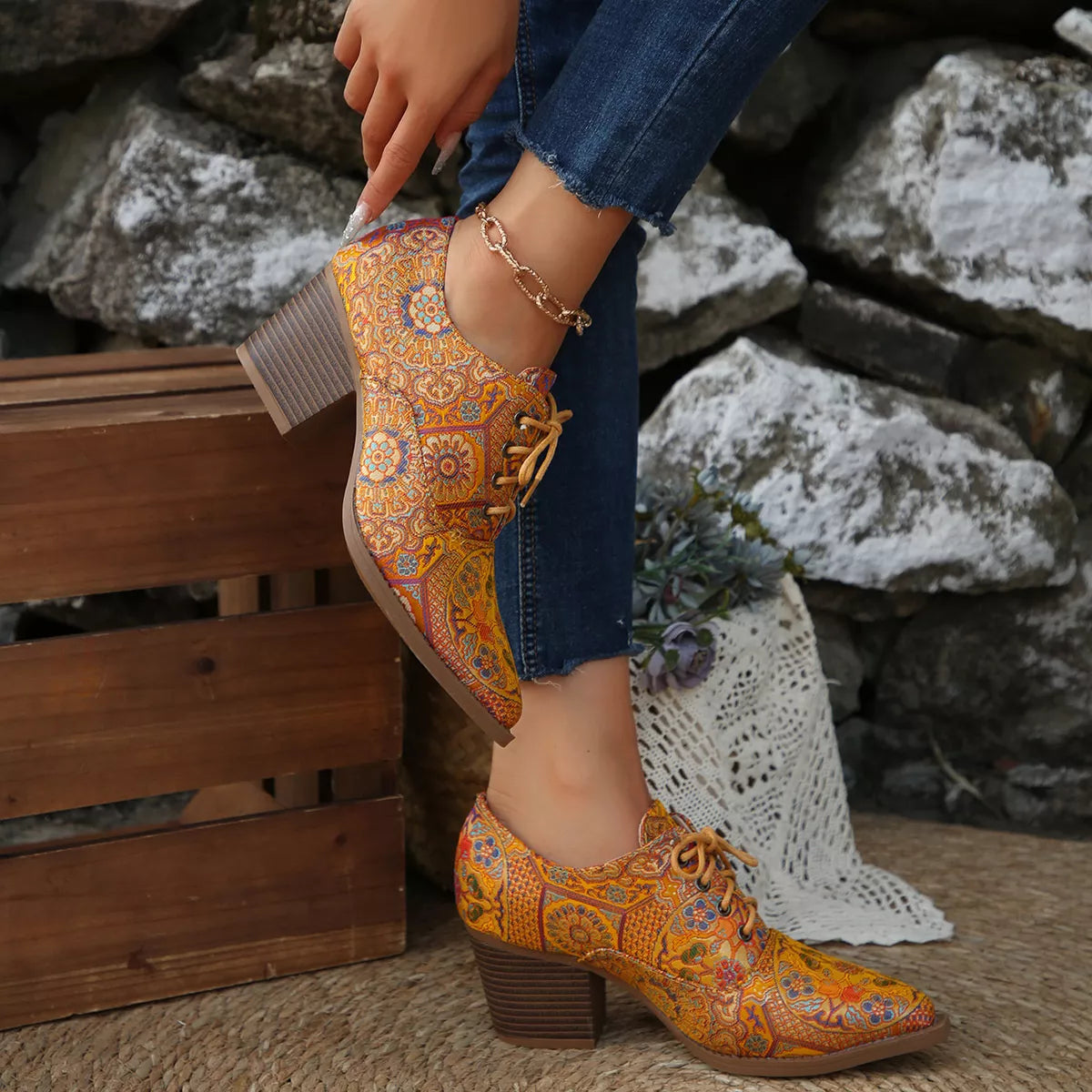 Point toe ankle boots against a plain backdrop