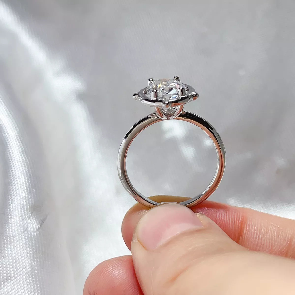 Oval cut moissanite ring shown at an angle to display the prong setting