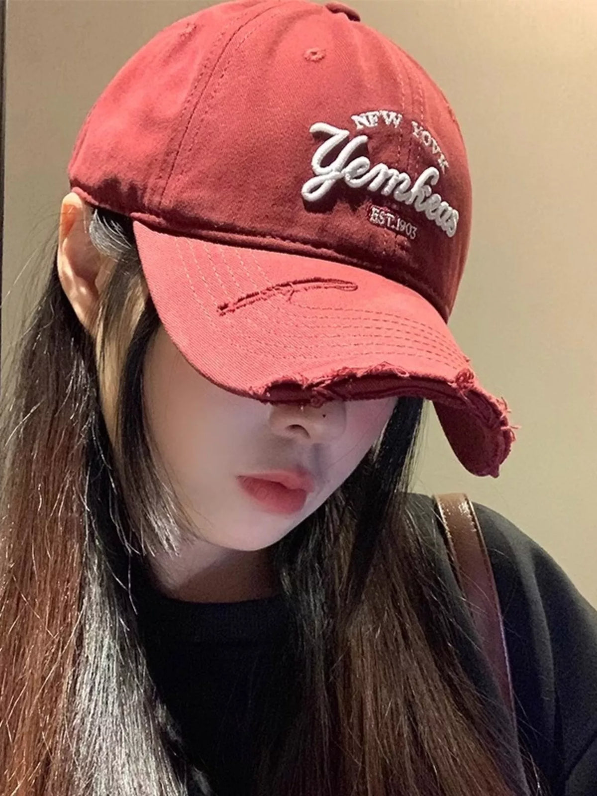 Distressed finish detail on the wine red baseball cap