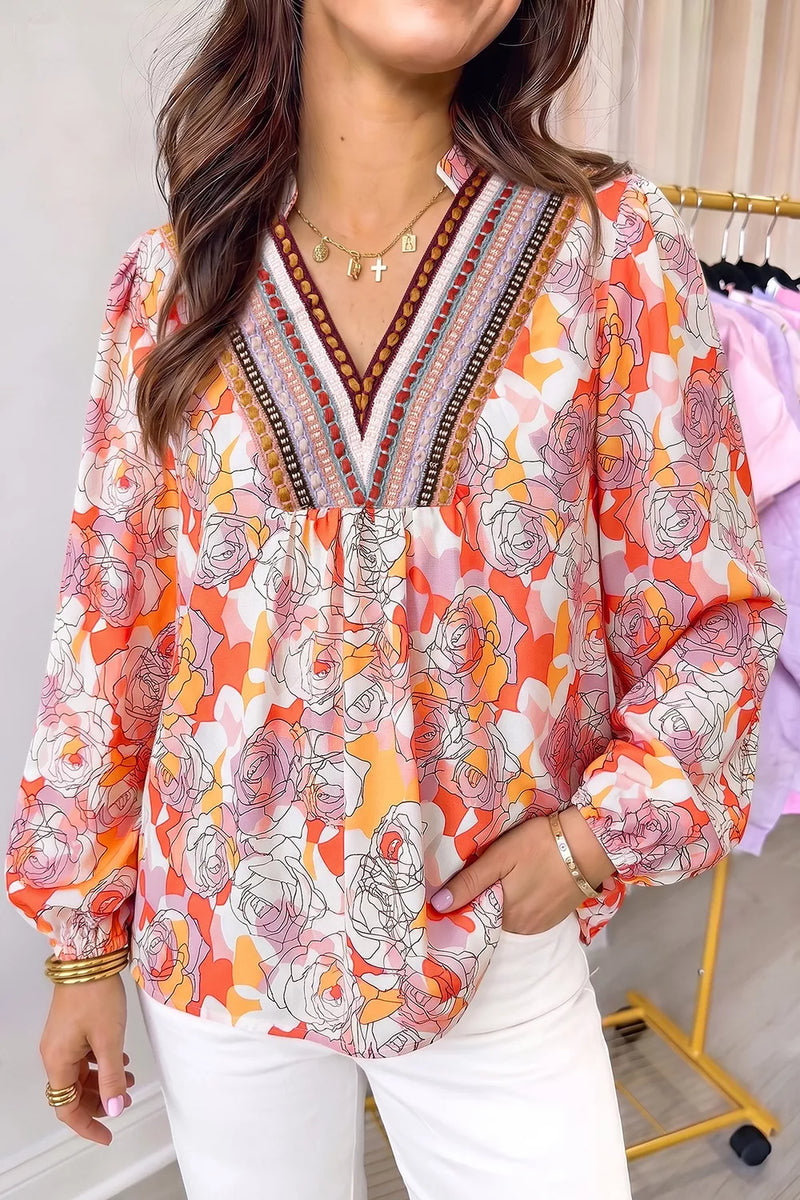 Floral print v neck long sleeve blouse in pale blush shown on a model