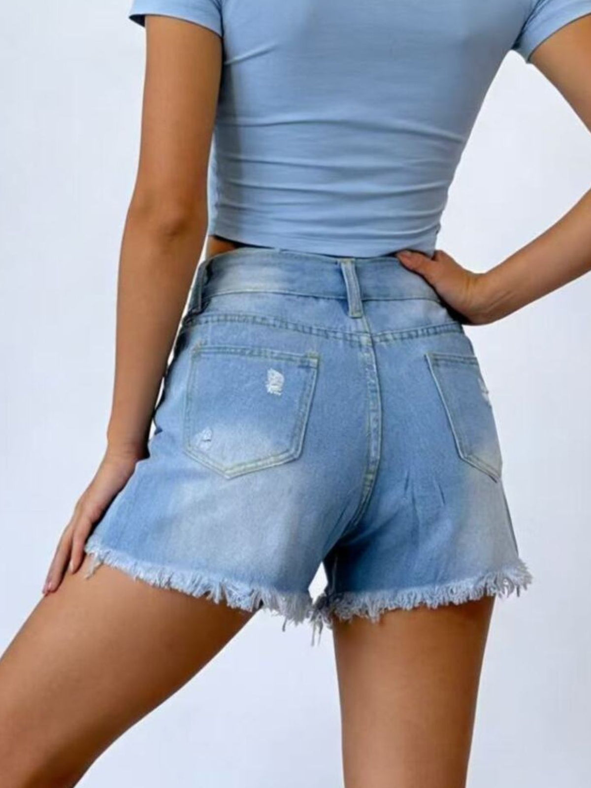 Flat lay of the distressed frayed hem denim shorts
