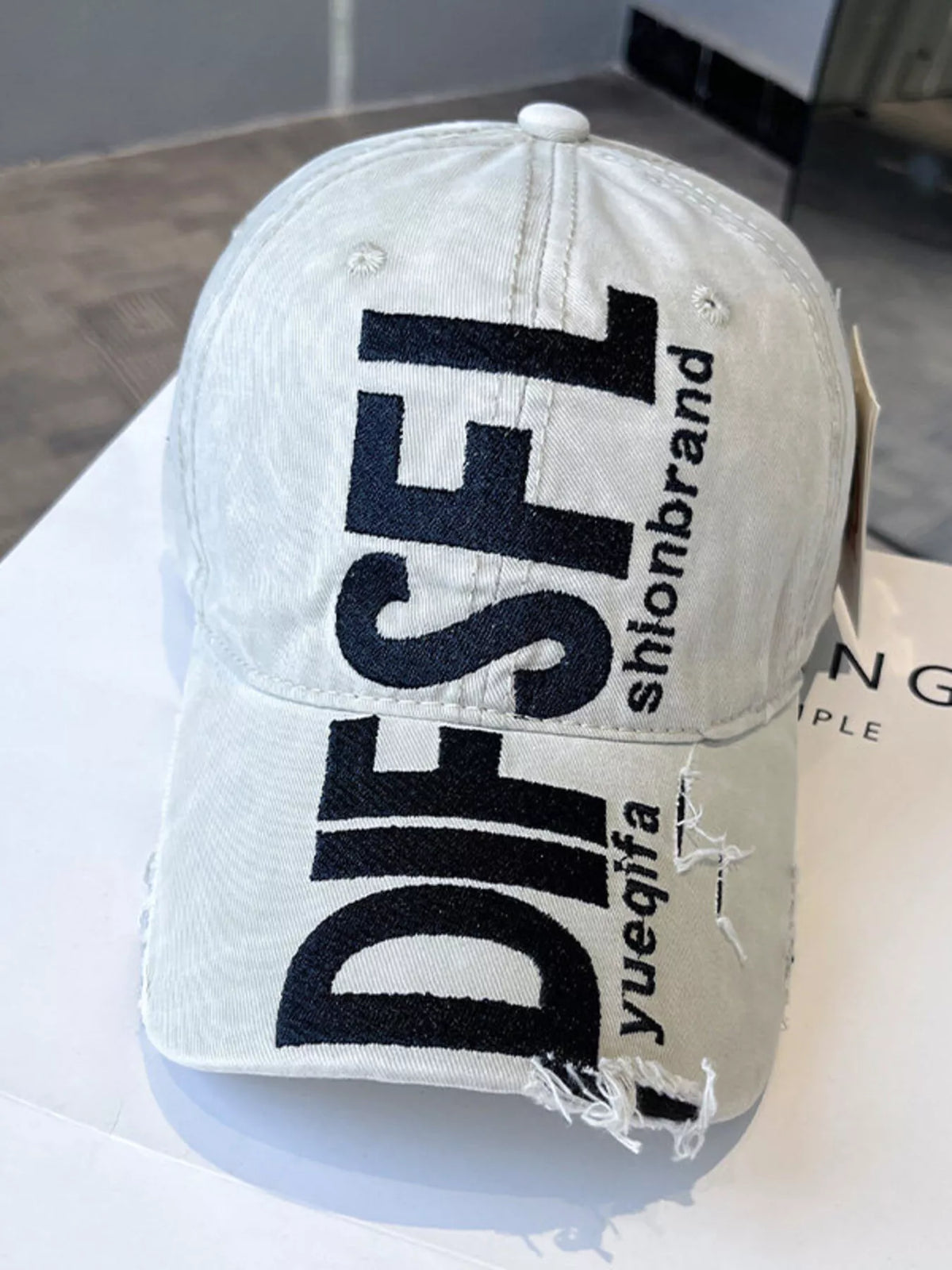 Distressed embroidered cap shown in a dark colourway