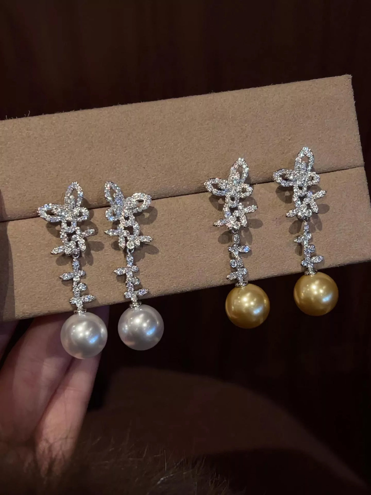 White butterfly pearl drop earrings close up detail