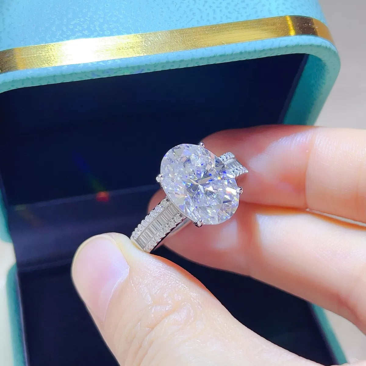 Large moissanite silver ring shown at an angle to display the setting