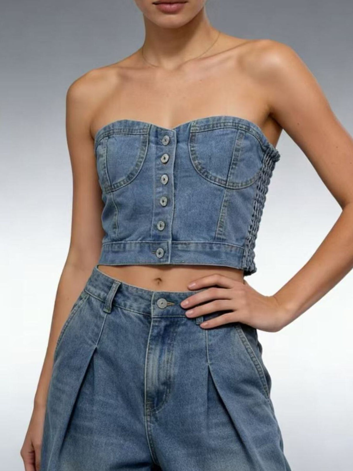 Model wearing the light blue denim button front tube top in a front view