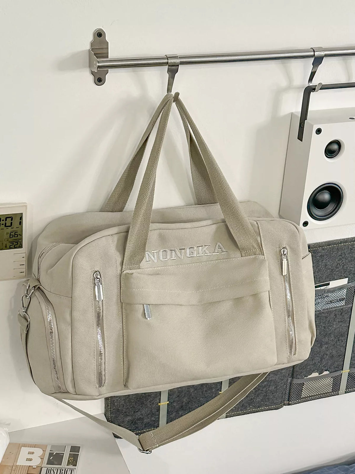 Model carrying beige canvas travel duffel