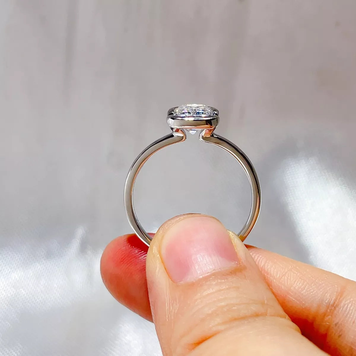 Emerald cut moissanite ring shown from above on a slim silver band