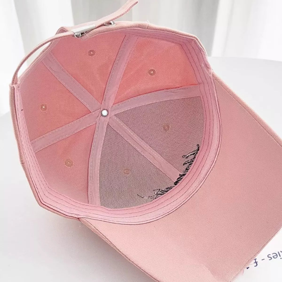 Embroidery detail against the distressed pink front panel