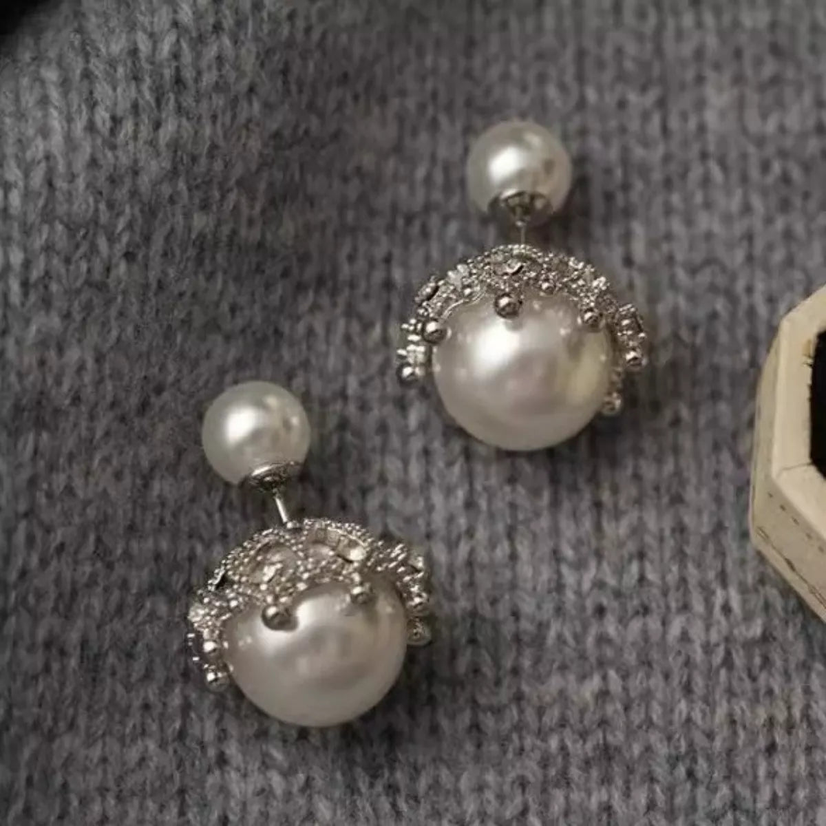 Pearl stud earring close up on silver needle