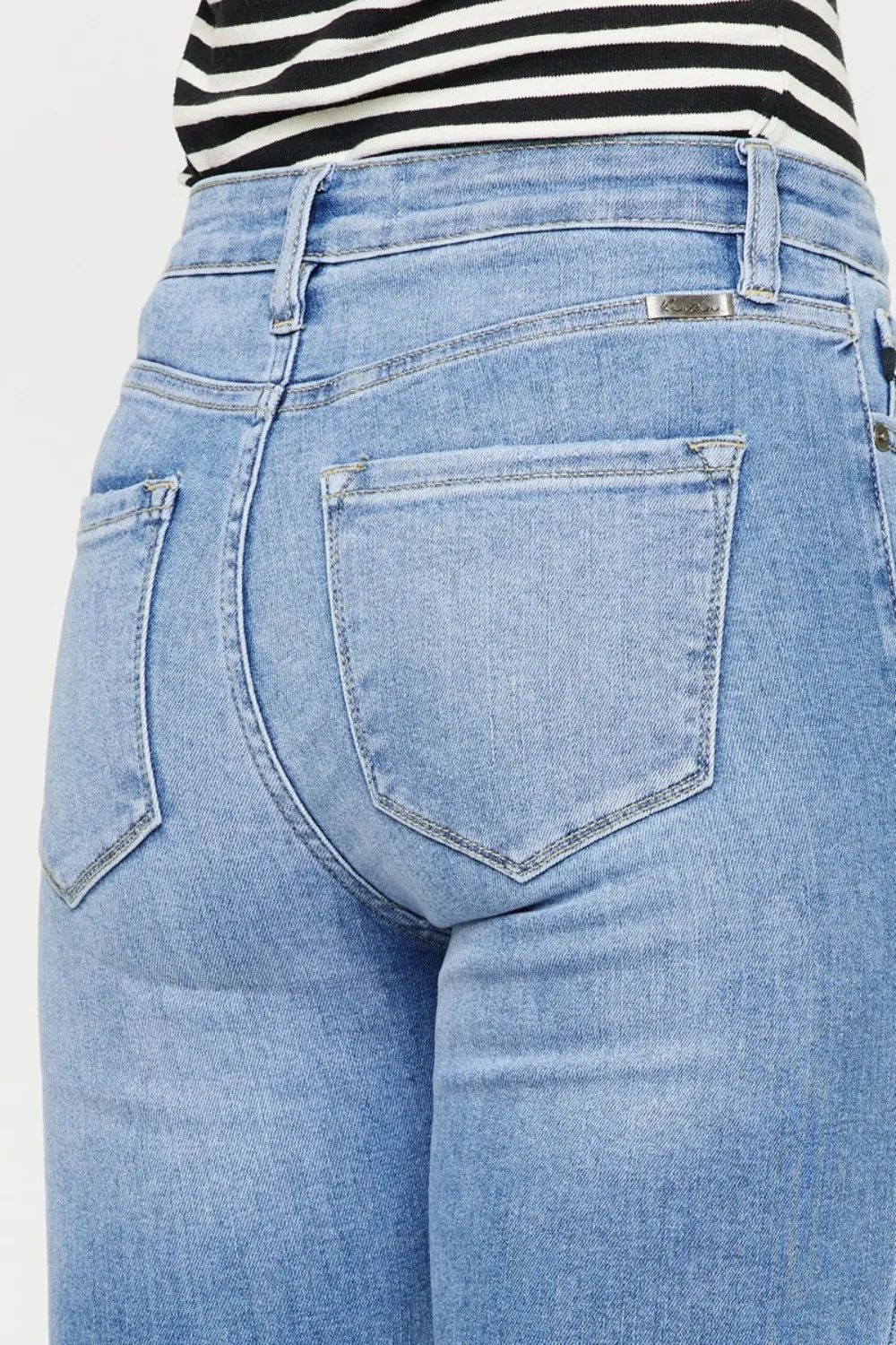 Button fly closure detail on distressed jeans