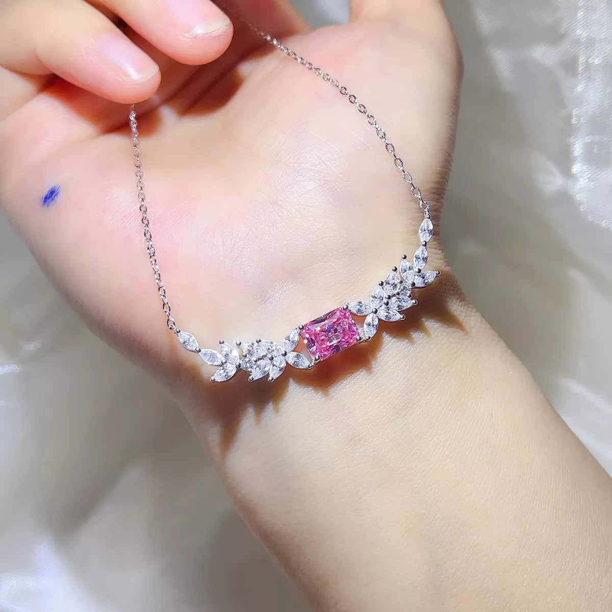 Pink moissanite pendant worn at the collarbone