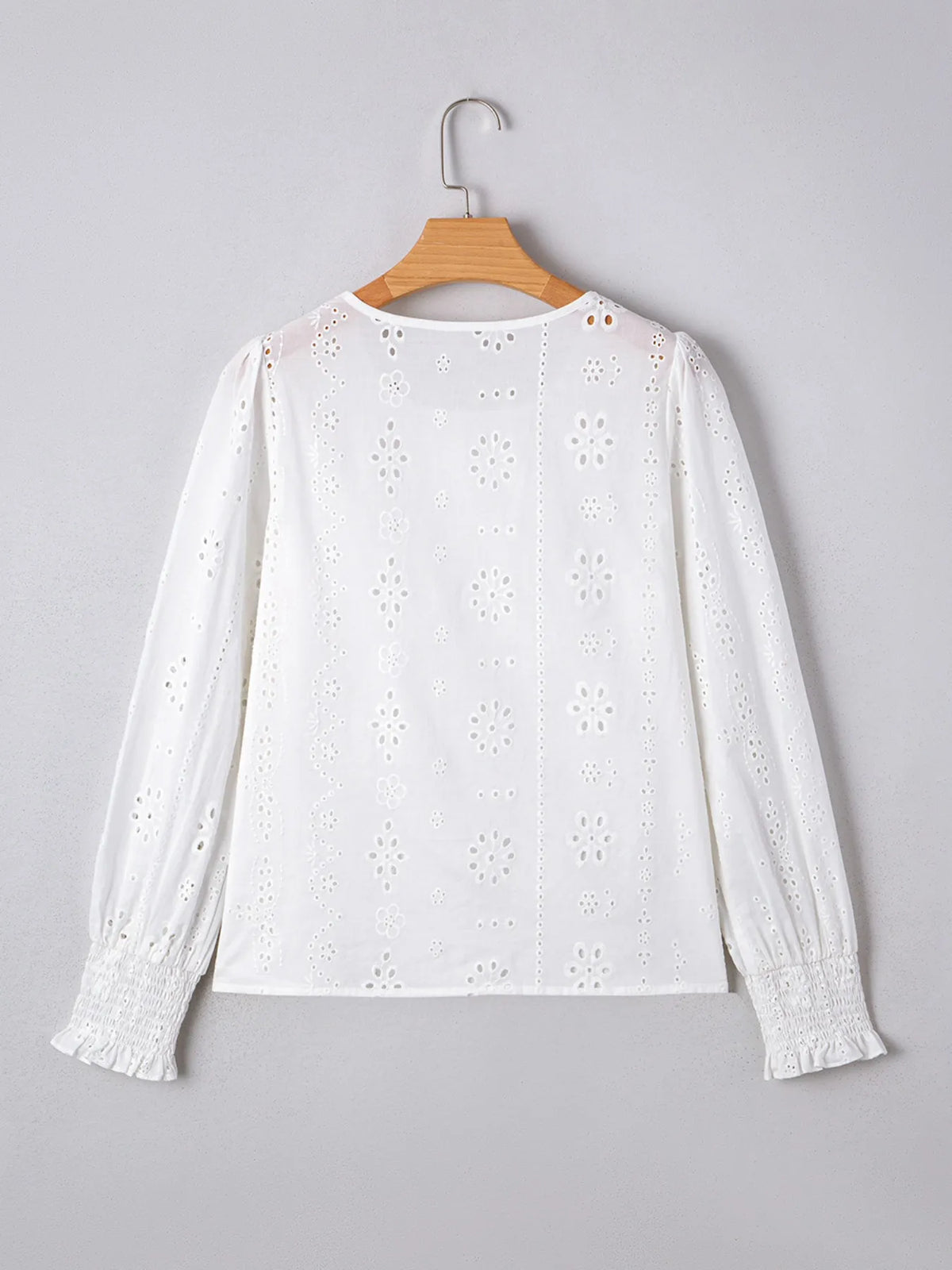 Eyelet fabric texture detail on white blouse
