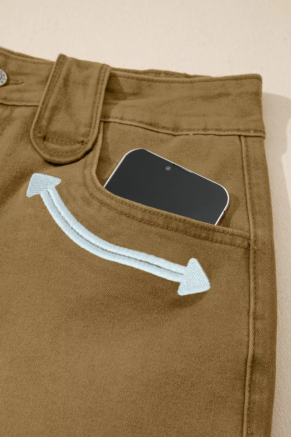 Model wearing brown denim shorts with a white tee
