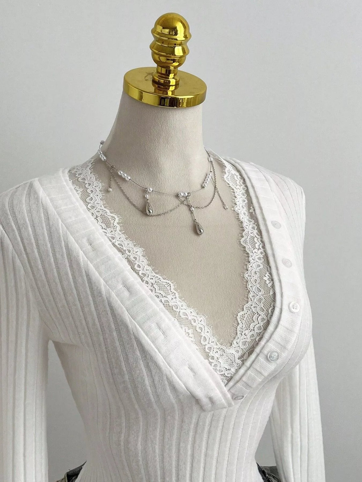 Decorative button detail on the ribbed knit top