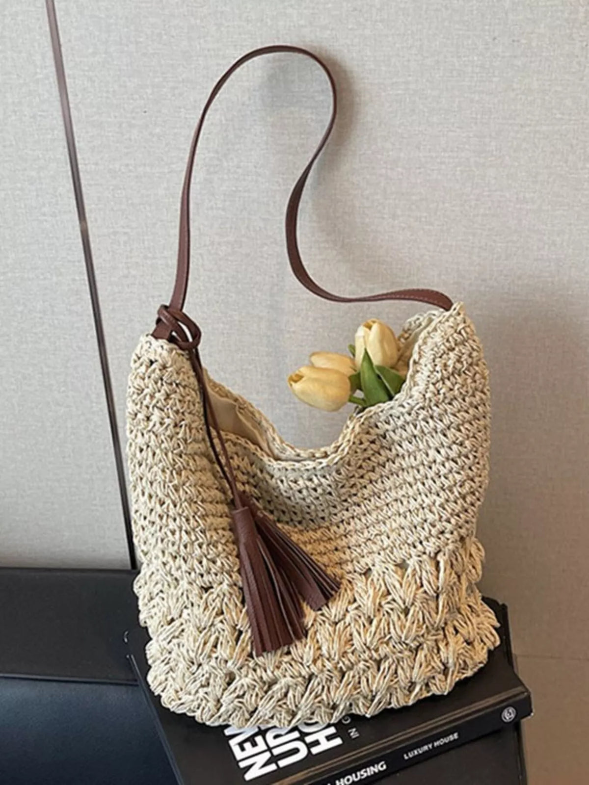 Straw tassel shoulder bag shown from the side