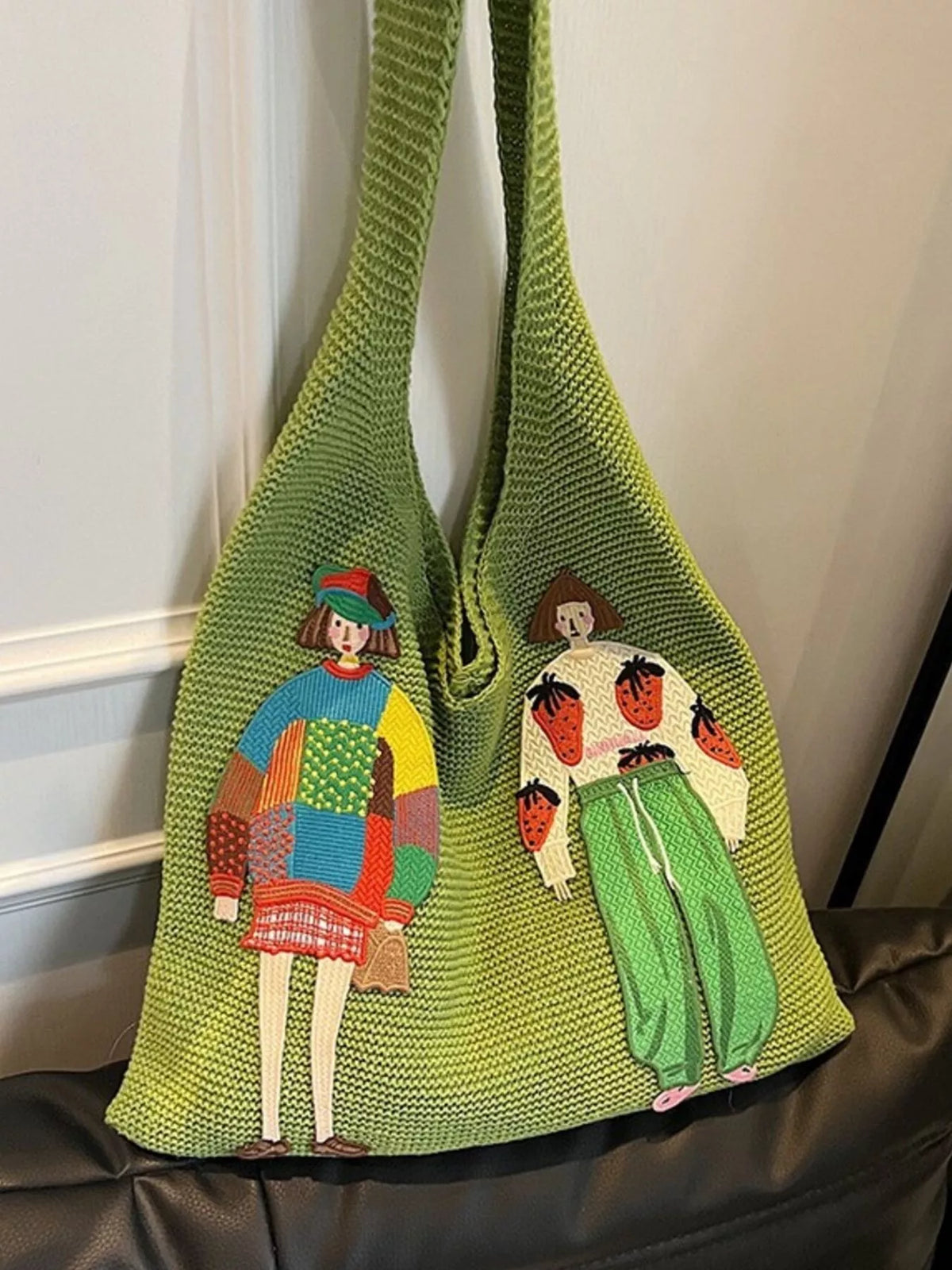 Embroidery detail on green knitted bag