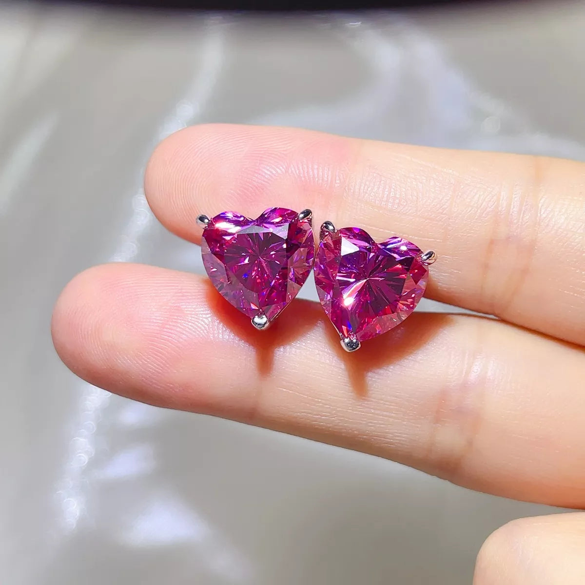 Pink moissanite heart stud earrings in sterling silver, front view