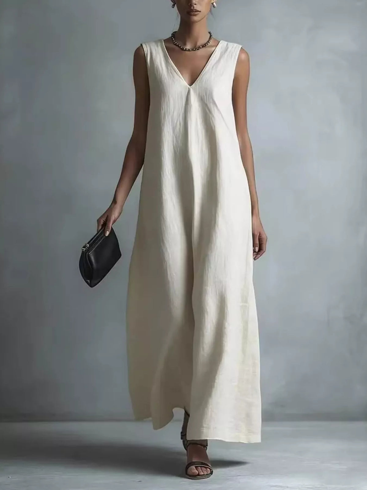 Sleeveless V neck maxi dress worn with flat sandals and a clutch
