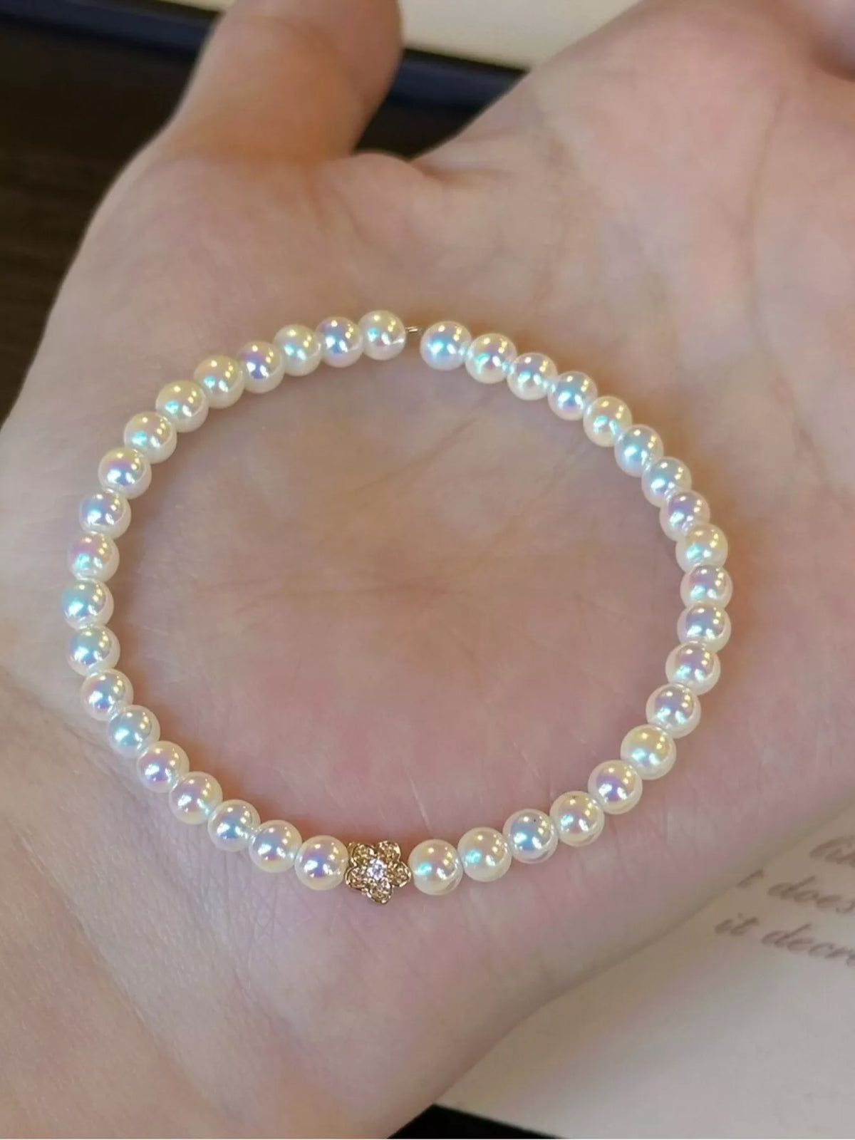 White pearl bracelet with gold floral accent