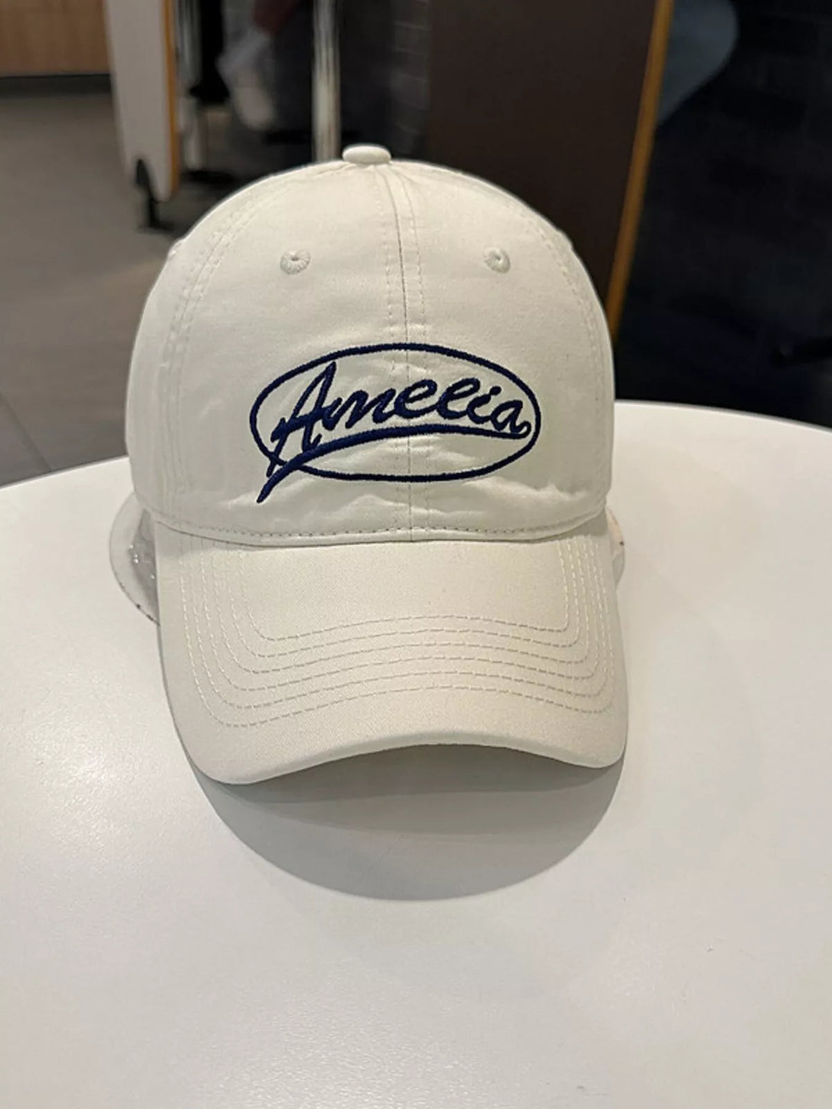 The embroidered cap shown in a darker colorway