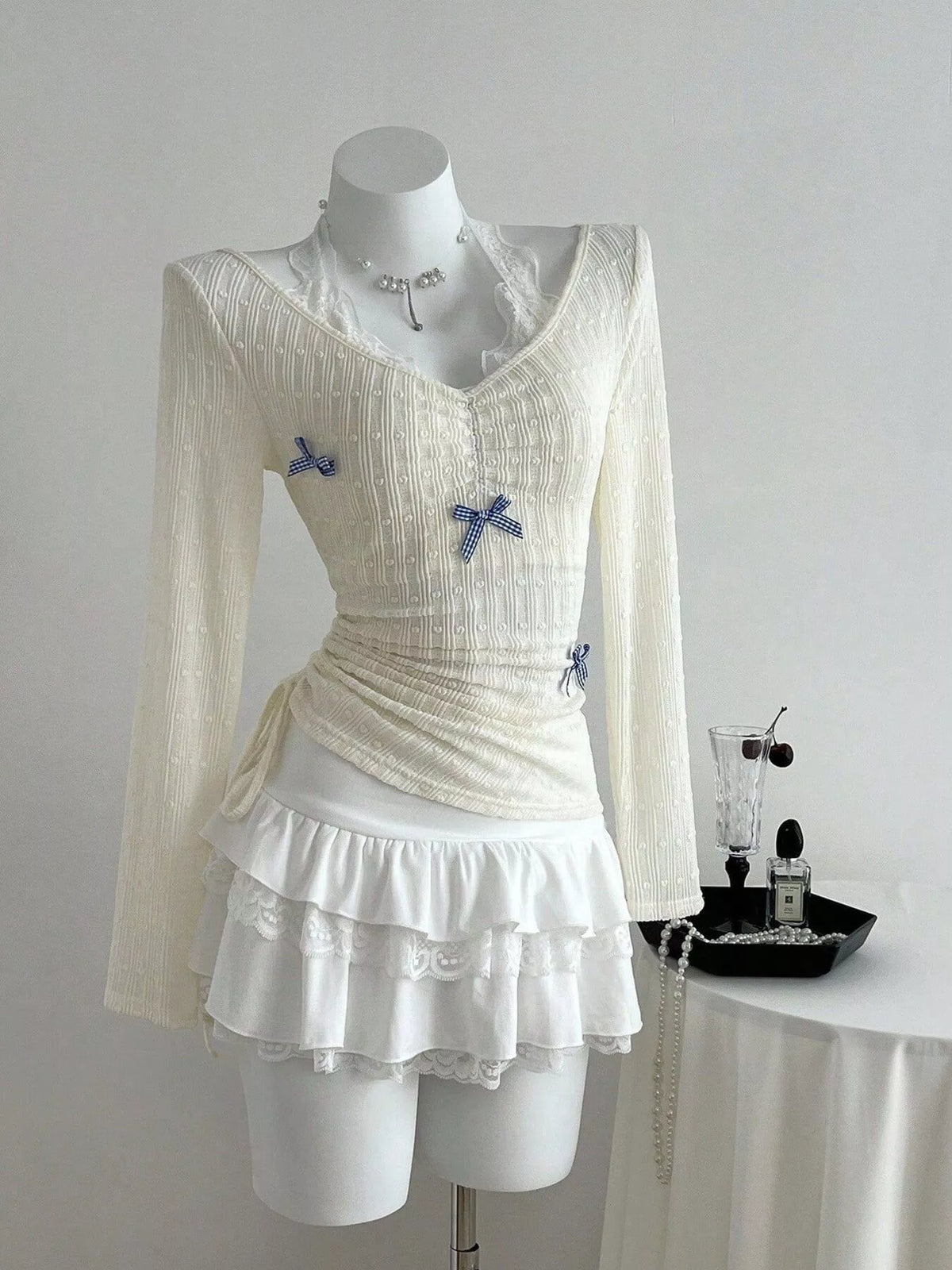 Fitted long sleeve top with lace trim and small bow details