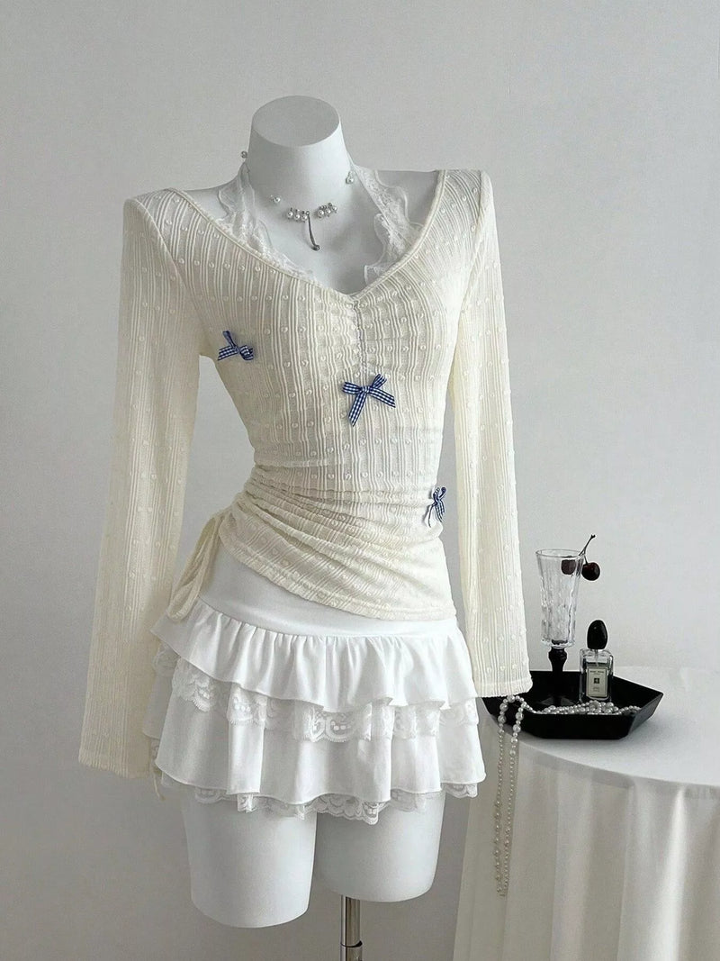 Fitted long sleeve top with lace trim and small bow details